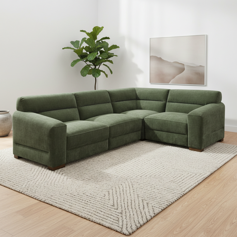 An L-shaped sectional sofa upholstered in textured sage green fabric, styled in a modern living room setting 