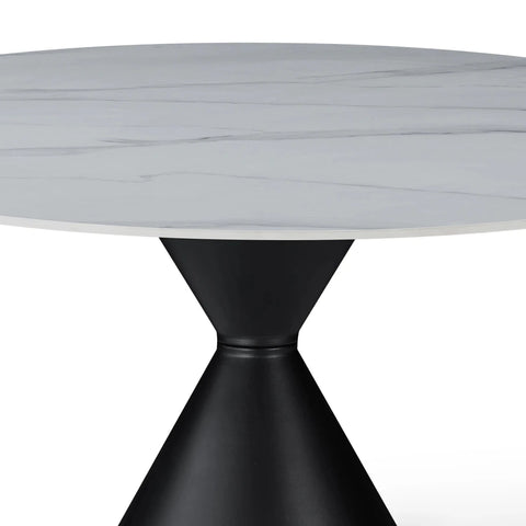 Round table with marble-like top and black base on a white background