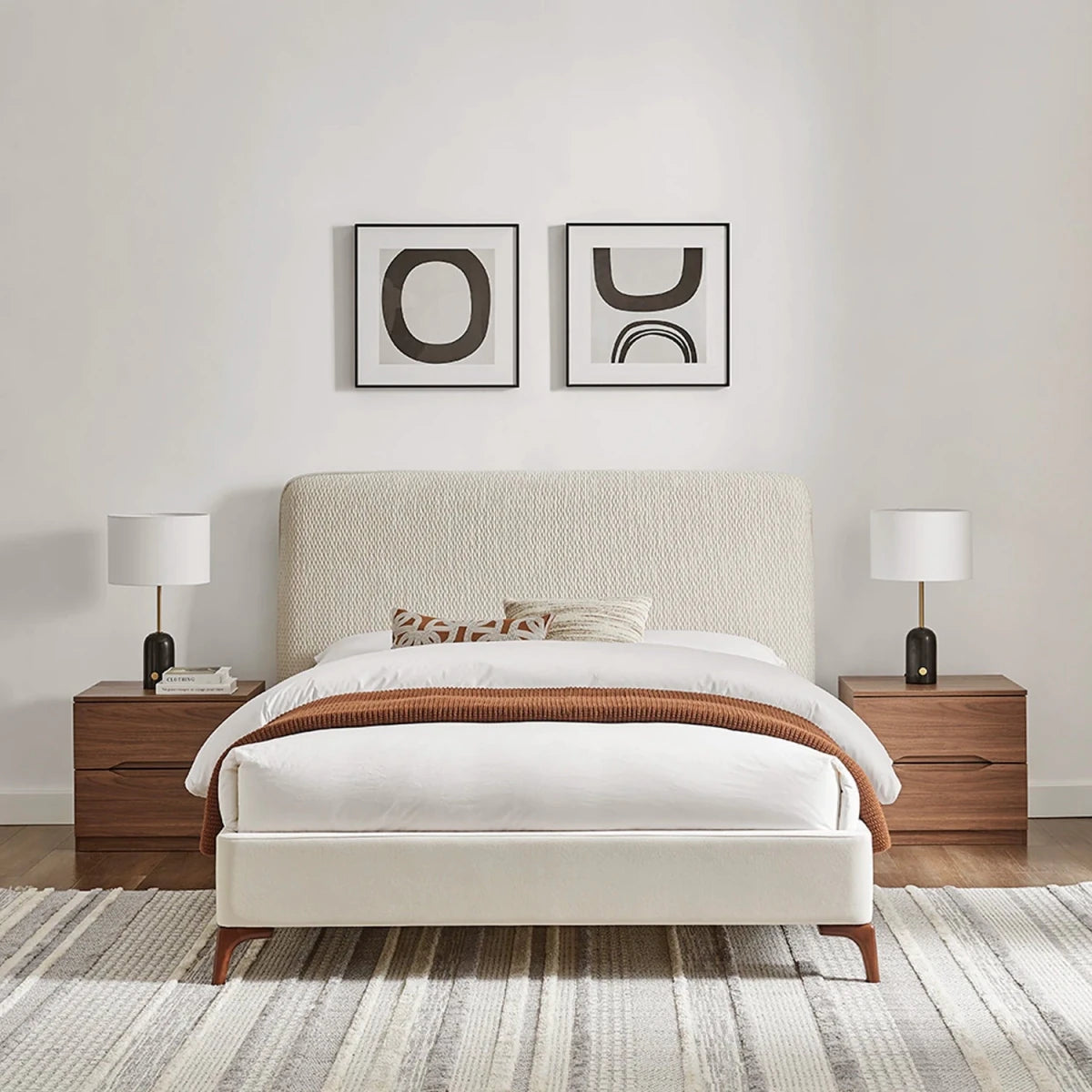 Front View of the Dovira Luxe Bed upholstered in natural fabric with a tall quilted textured headboard and velvet footend. Available in Grey or Natural fabric and in sizes Double or Kingsize.