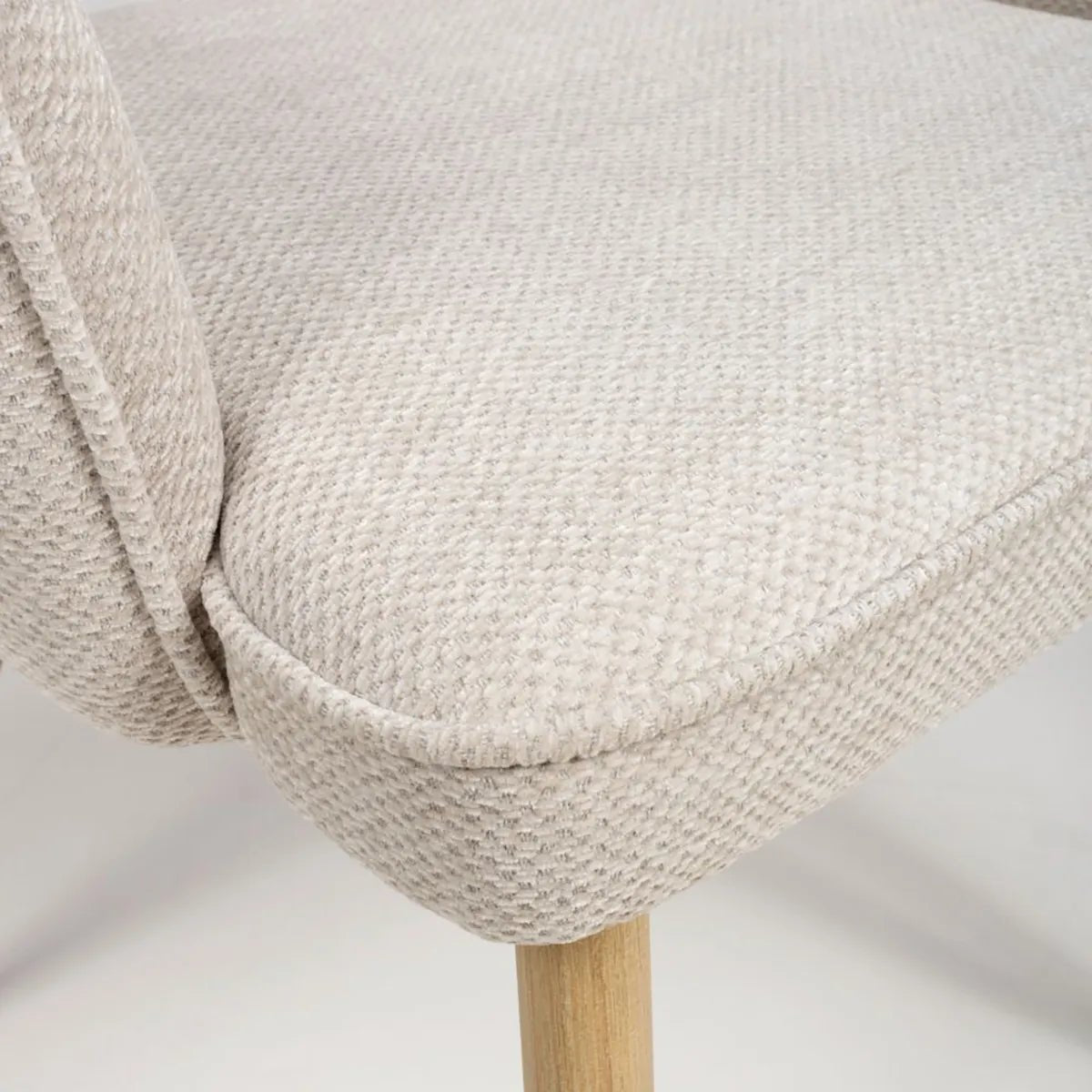 Fabric Close Up of Eaton modern dining armchairs in Natural fabric. Soft padded seat, light wood legs & ergonomic shape for comfort & style.