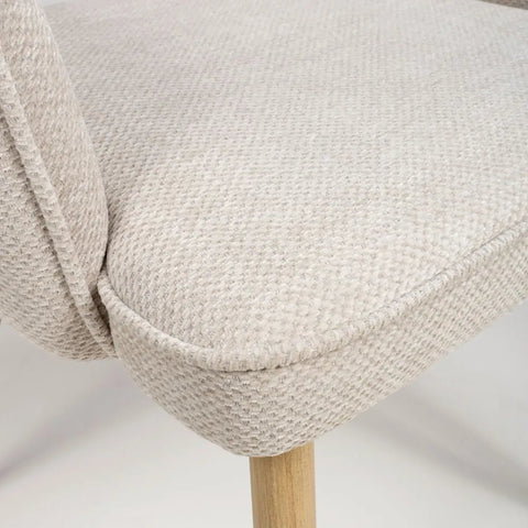 Fabric Close Up of Eaton modern dining armchairs in Natural fabric. Soft padded seat, light wood legs & ergonomic shape for comfort & style.
