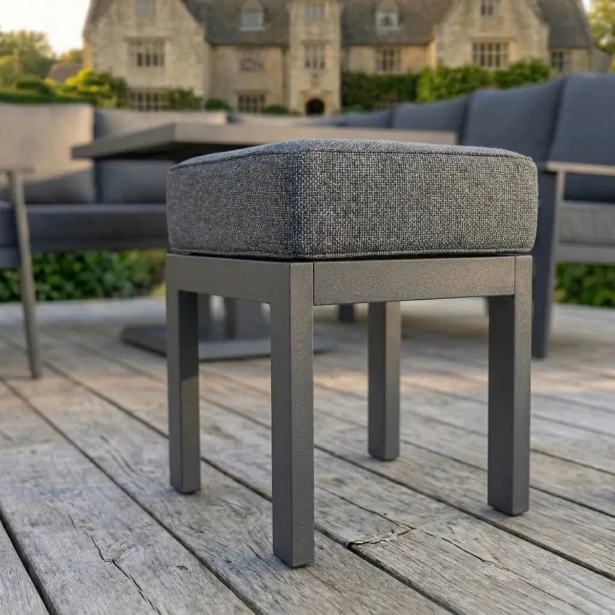 Durable outdoor stool with soft cushion and sleek grey finish.