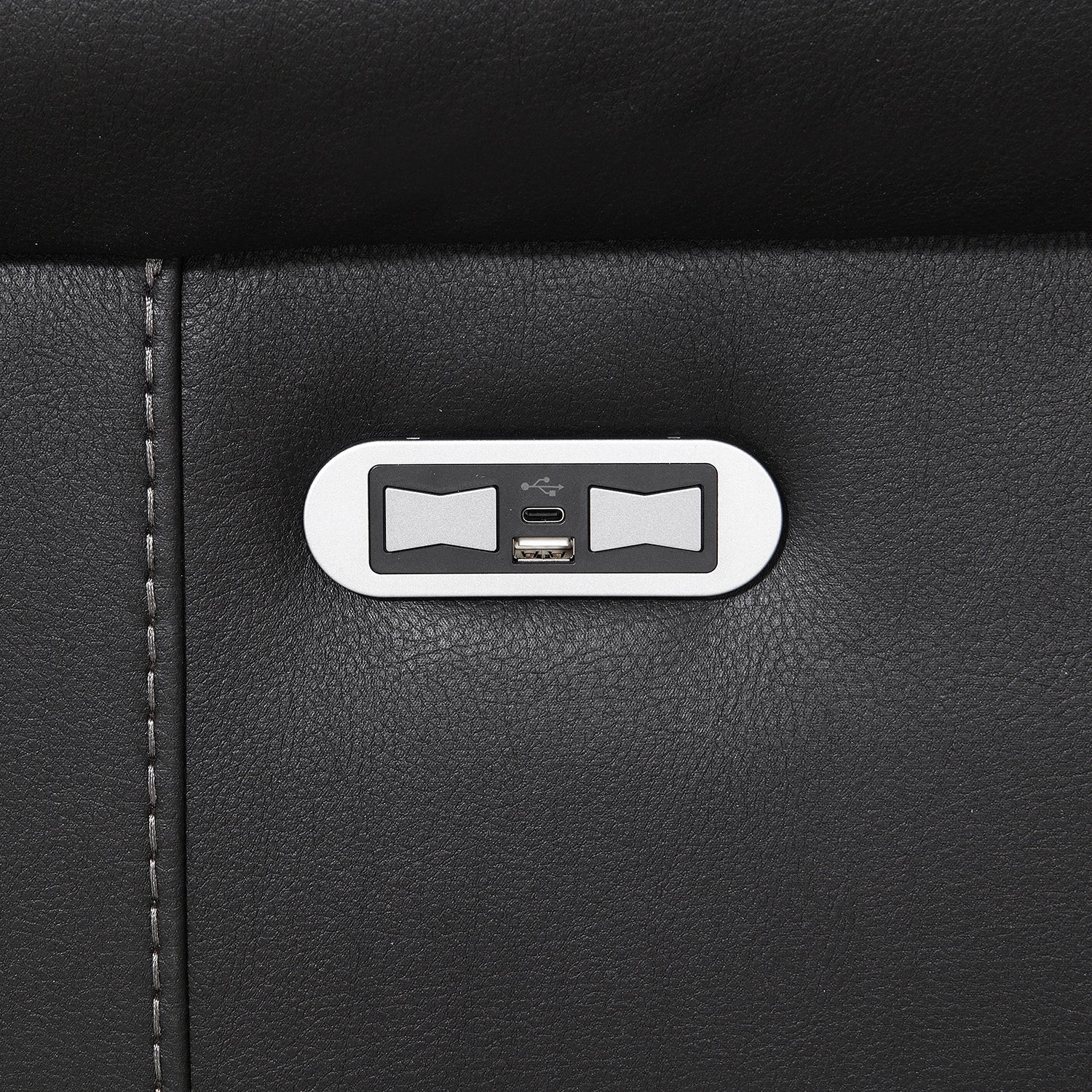 Close-up of a Flynn Black Power Recliner 3 Seater Sofa with a silver oval control panel featuring two bowtie-shaped buttons and a USB-C port.