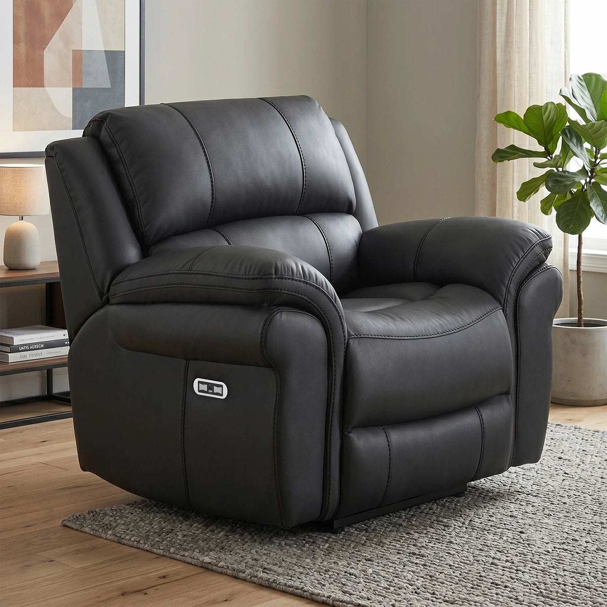 A black leather recliner chair with a power control panel on the side, shown in a styled living room setting on a gray rug.