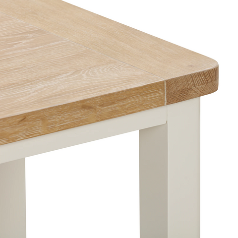 Close-up of a Foxington Lamp Table with a light oak wood tabletop and off- white  painted frame and legs. Image shows the wood grain and joint detail on a white background.