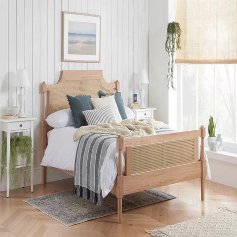 Elegant oak bed frame with rattan headboard.