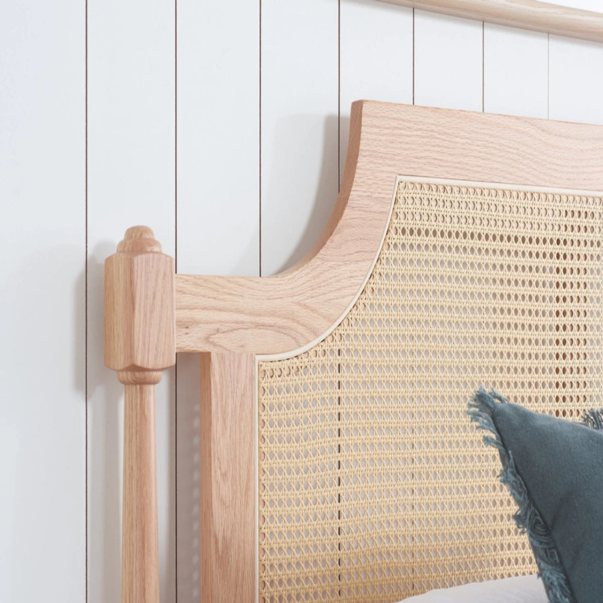 Elegant oak bed frame with rattan headboard.