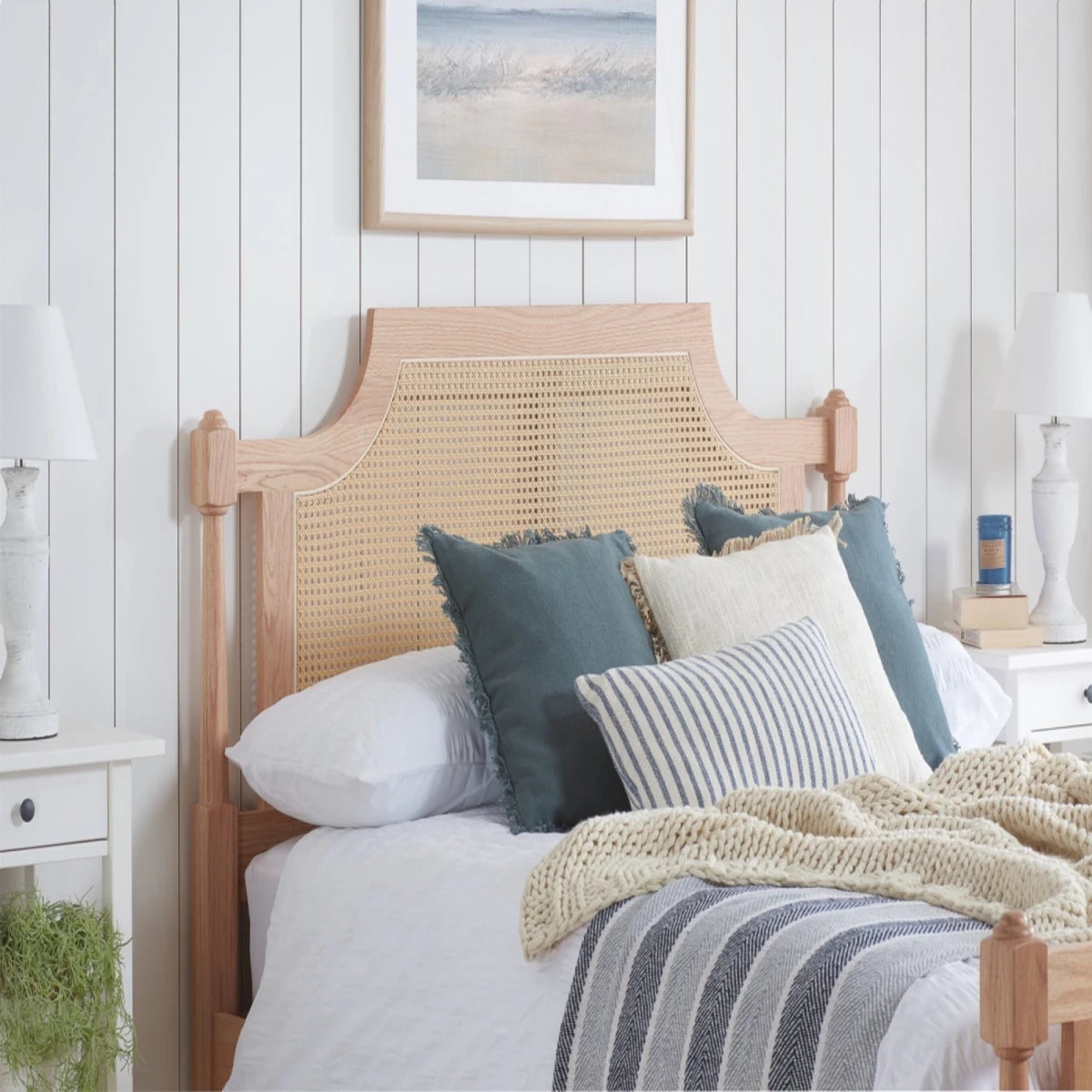 King size wooden bed with natural oak finish and woven rattan accents.