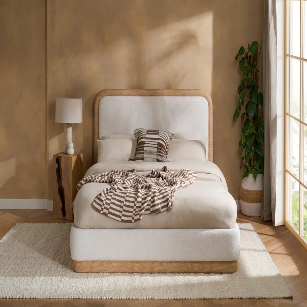 Luxury double bed with curved headboard and soft fabric upholstery.