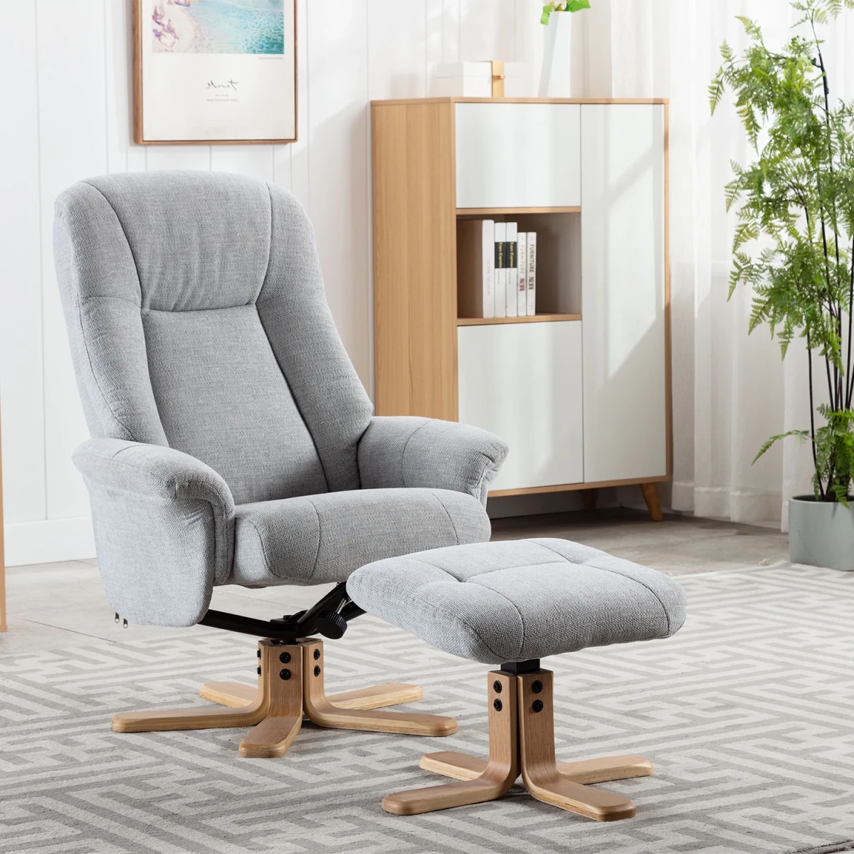 A light gray fabric bigelow recliner chair with a matching ottoman, both with wooden swivel bases, shown in a bright, modern living room setting.