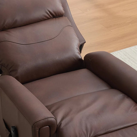 A close-up of a brown leather recliner chair showing the padded backrest, armrests, and seat cushion, set against a light wood floor and a small rug.