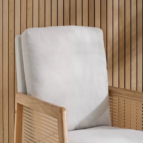 Modern armchair with rattan sides and soft cushions.