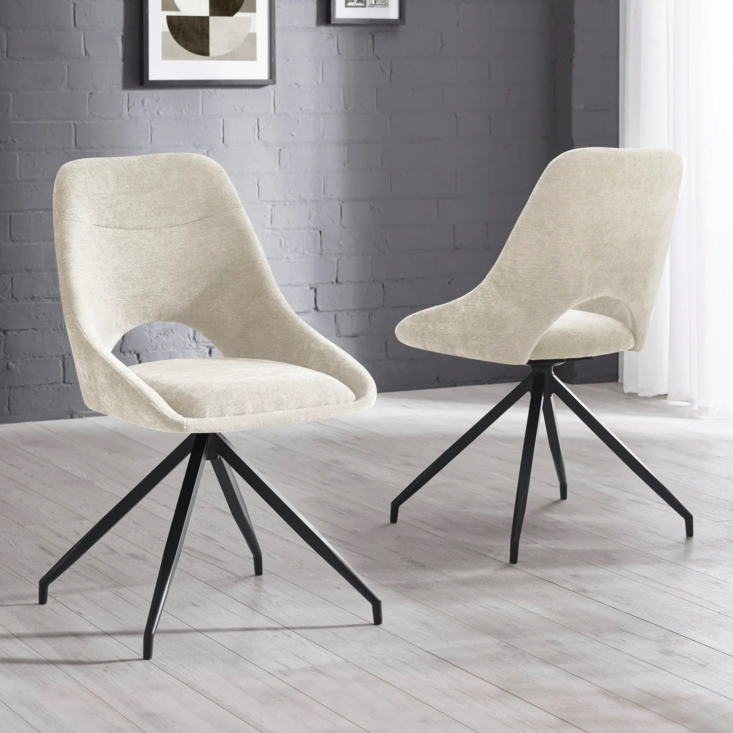 Two beige chairs with black metal legs on a light wooden floor against a gray brick wall.