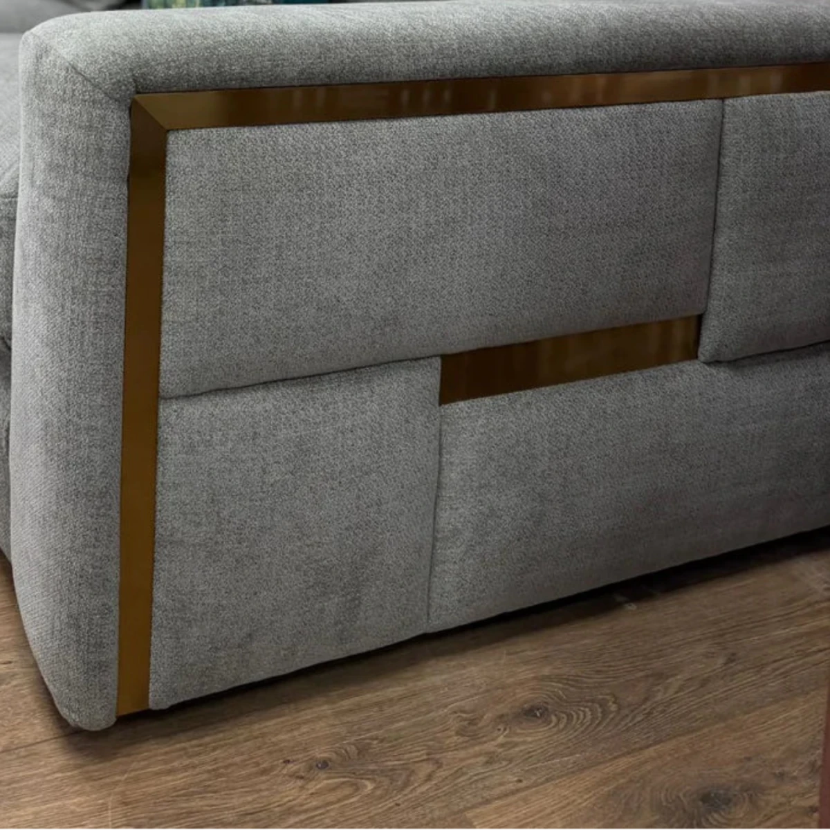 Modern grey corner sofa with elegant armrest detailing.