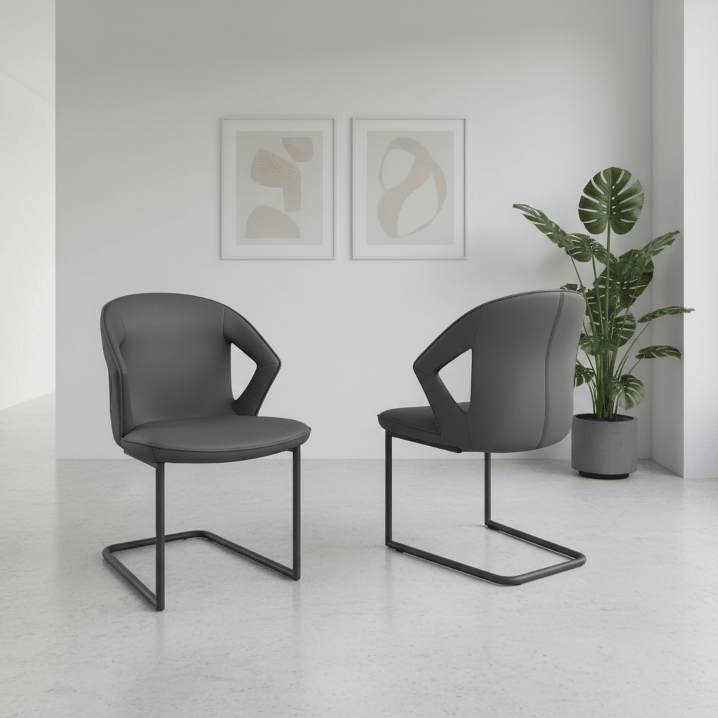 Two modern Kenzo dark gray Leather upholstered dining chairs with black cantilever metal bases, shown in a minimalist white room with abstract wall art and a potted plant.