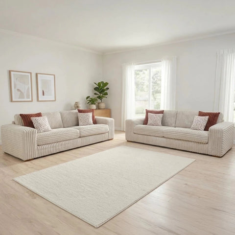 Luton Versailles fabric sofa with cord upholstery, Mahogany and Oak feet, and patterned cushions.