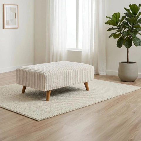 Compact fabric footstool for living room.