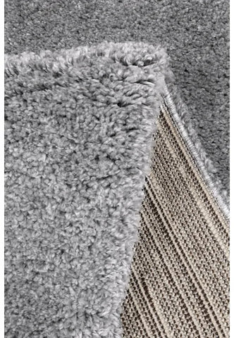 Detailed rug pile showing soft and fluffy grey material.