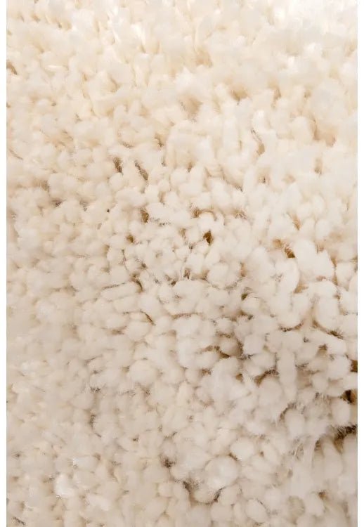 Shaggy rug close-up showing deep pile and soft ivory fibers.
