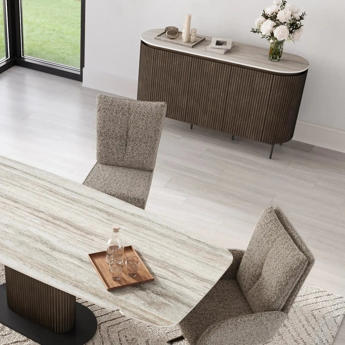 Modern dining room with marble table, chairs, and sideboard.