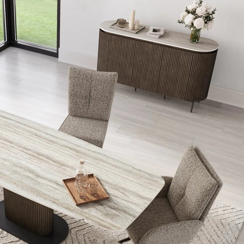 Modern dining room with marble table, chairs, and sideboard.