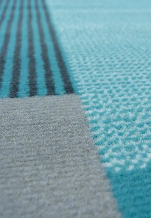 Teal rug with modern design and durable polypropylene fabric.