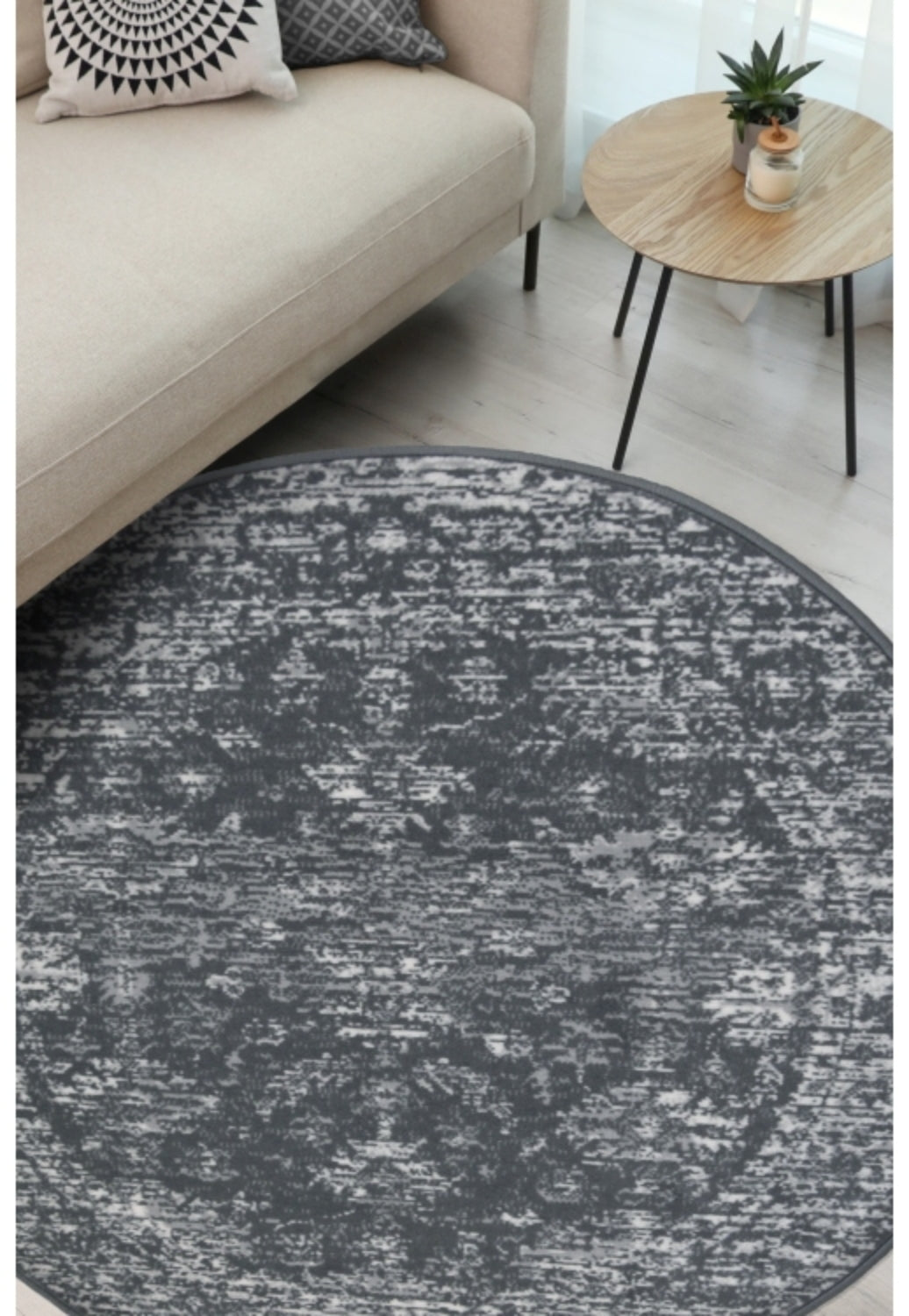 Round charcoal rug with traditional pattern and durable polypropylene fabric.