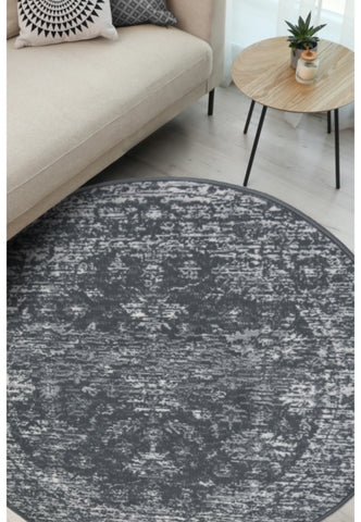 Round charcoal rug with traditional pattern and durable polypropylene fabric.