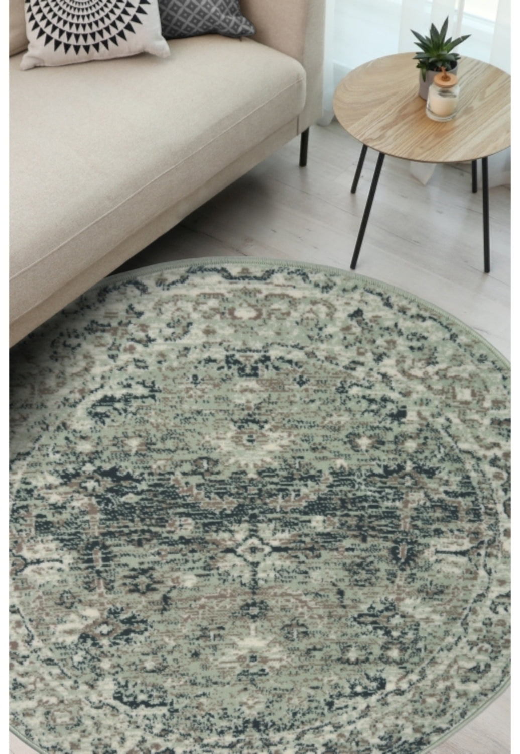 Round sage green rug with traditional inspired pattern.