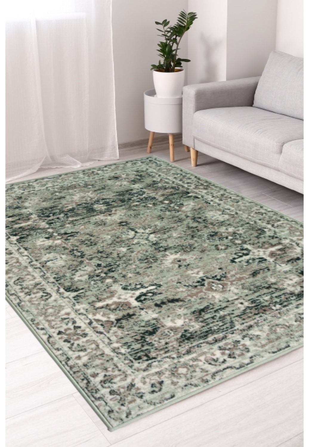 Sage green rug with traditional inspired pattern.