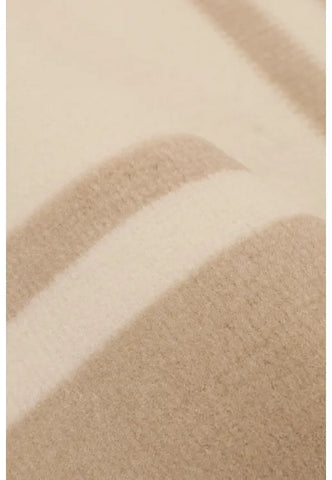 Neutral rug with subtle scallop edge detailing.