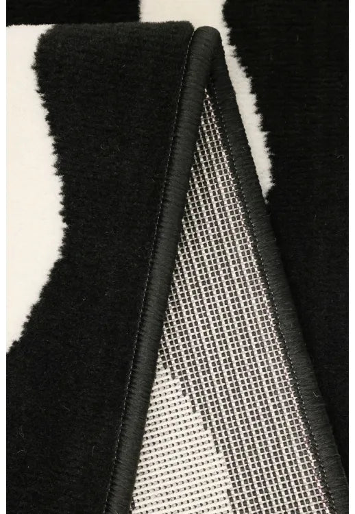 Contemporary rug with geometric scallop detailing in black tones.