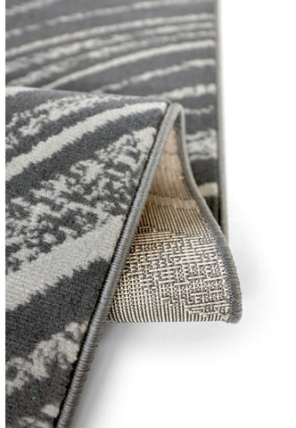 Abstract swirl rug in deep charcoal tones.