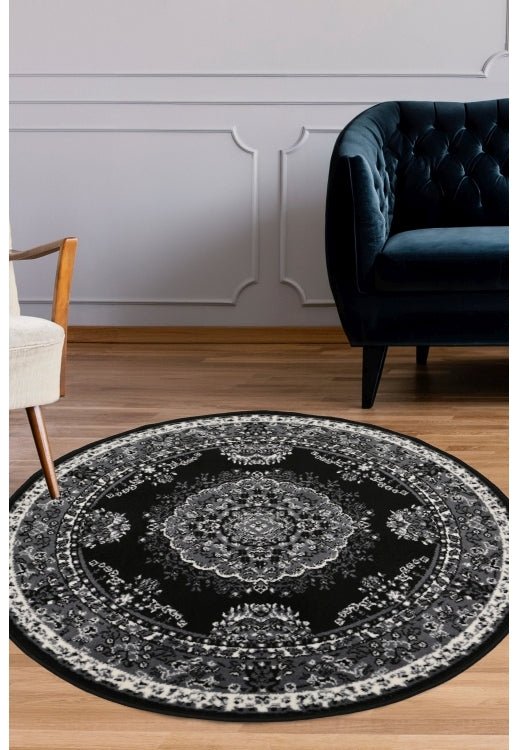 Round black and grey rug with geometric pattern design.