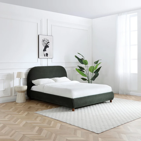 Lifestyle image of the Mallow Olive Boucle Fabric Upholstered Bed with Walnut Legs