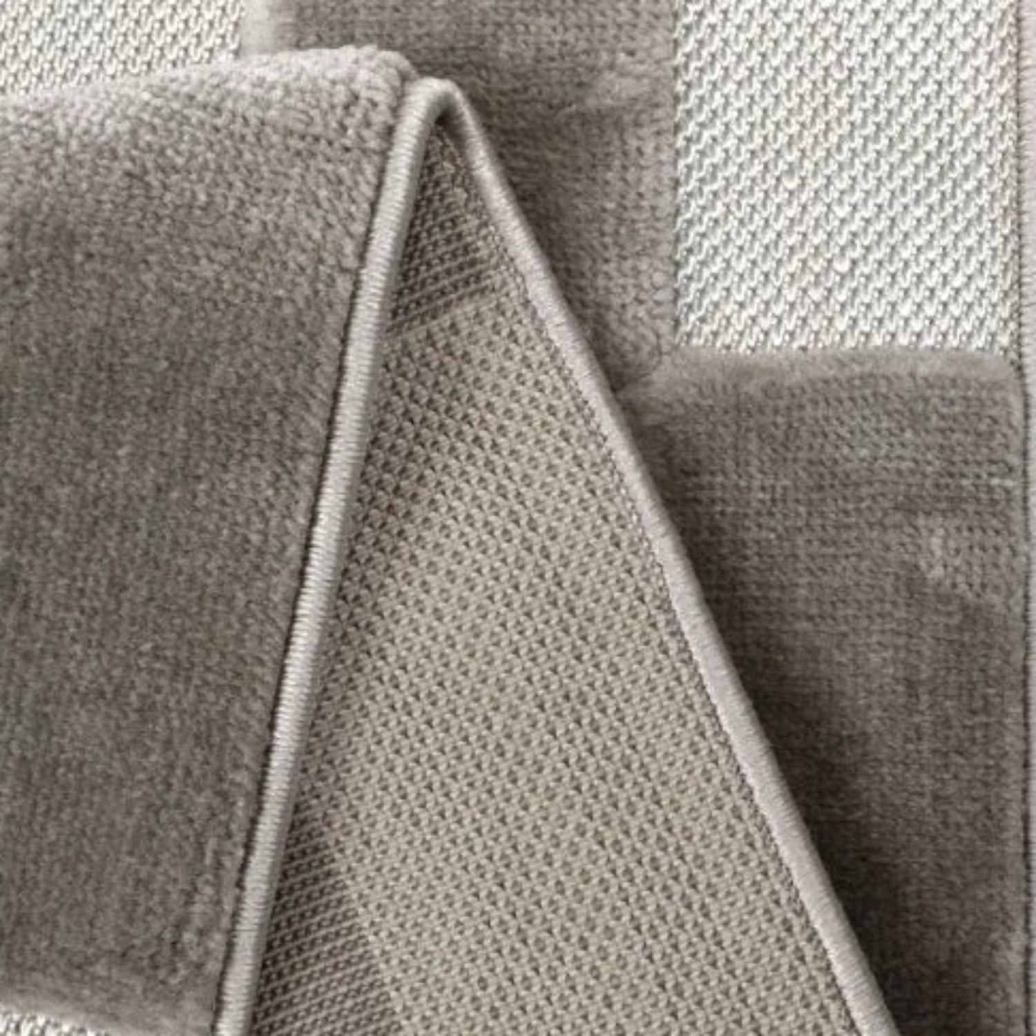Textured rug with cut and flat pile creating 3D effect.