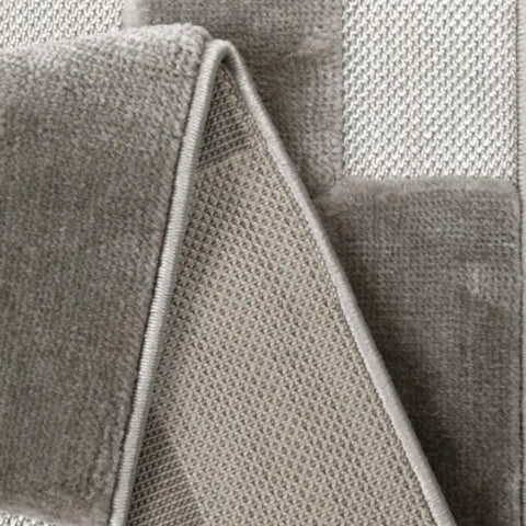 Textured rug with cut and flat pile creating 3D effect.
