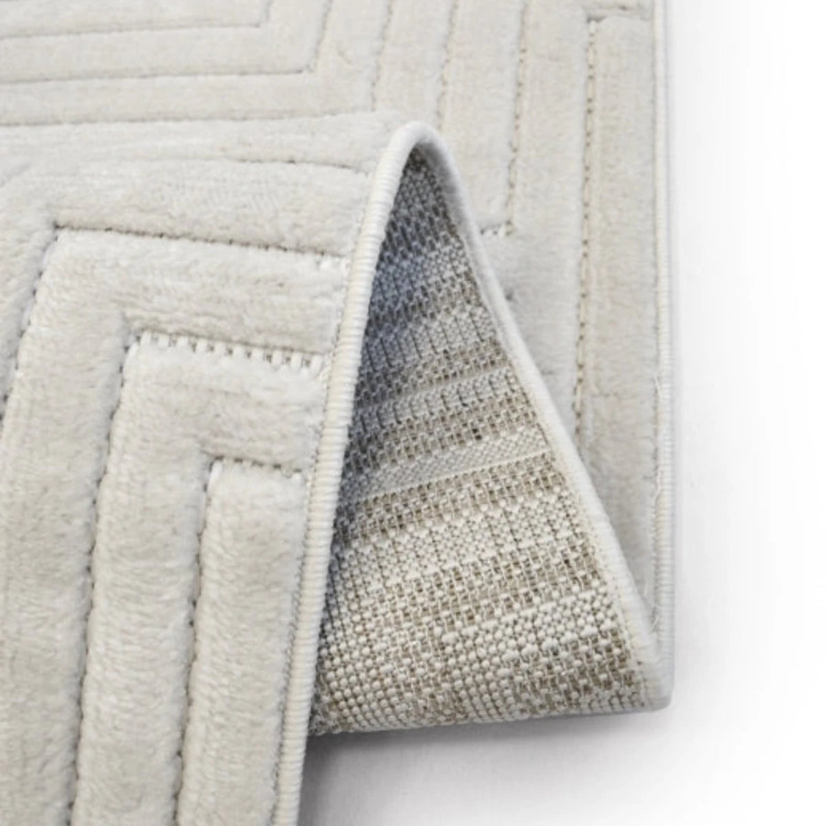 Modern white rug with intricate geometric maze design.
