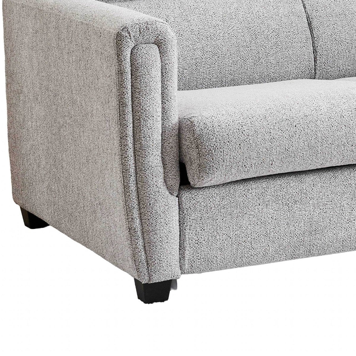 Close-up of a light gray textured fabric sofabed showing the armrest, seat cushion, and dark wooden legs against a white background.