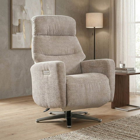 Beige swivel recliner chairwith chrome star shape base  in a living room setting with a lamp and table.