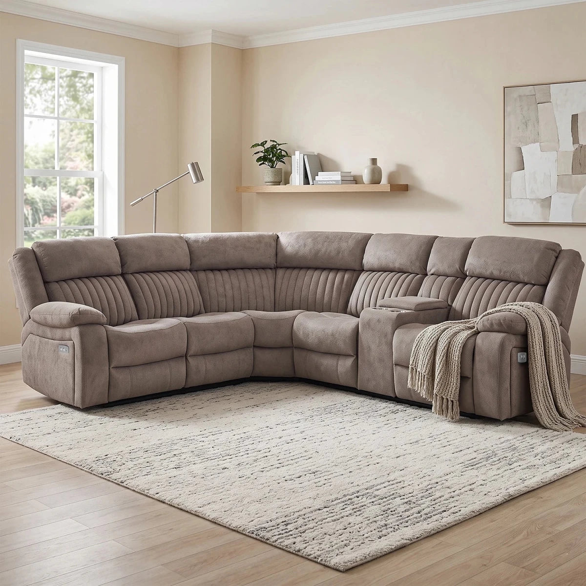 A large L-shaped sectional sofa upholstered in taupe microfiber fabric, shown in a staged living room setting with a patterned area rug, light wood flooring, and beige walls.