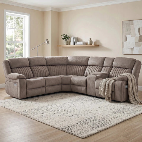 A large L-shaped sectional sofa upholstered in taupe microfiber fabric, shown in a staged living room setting with a patterned area rug, light wood flooring, and beige walls.