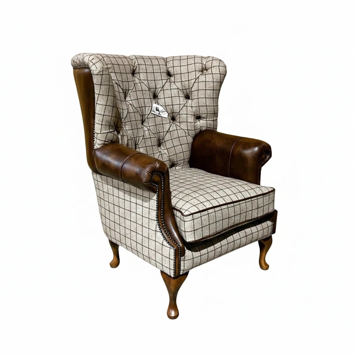 British handmade beige check wing chair with antique tan leather and button tufting. A classic country-inspired statement piece.