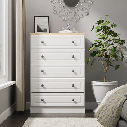 Norfolk White Ash 5 Drawer Chest, Norfolk is a two colour tone Bedroom Furniture which has Bardilon oak top and painted base. Available in choice of 3 colours White, Kashmir and Grey. Fully Assembled. Quick Delivery - Lifestyle Image