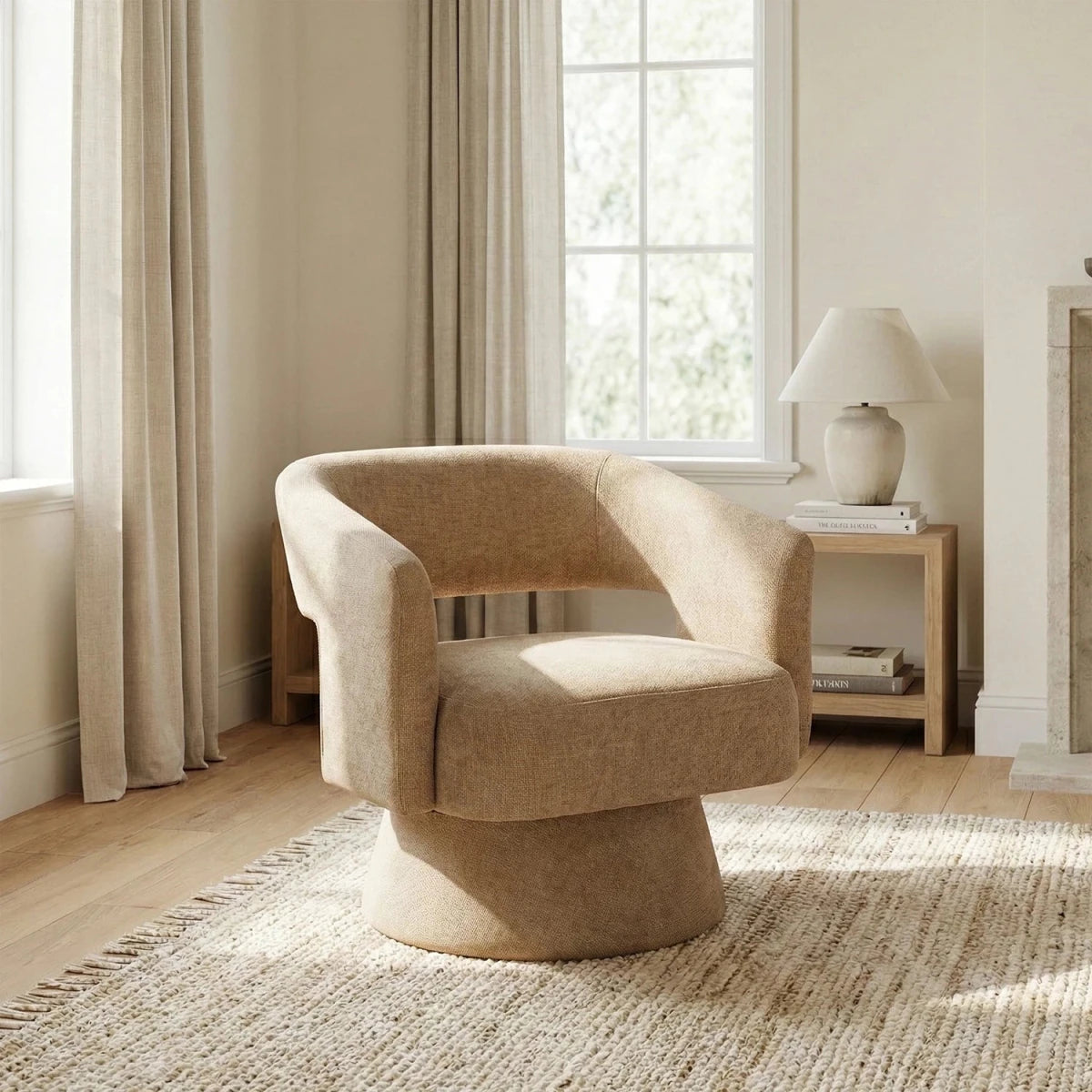 Beige armchair in a living room with curtains and a lamp.