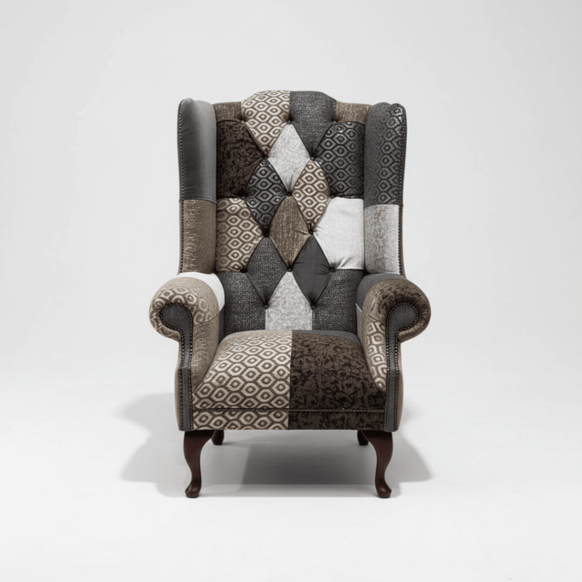 Wiston patchwork Chesterfield wing chair in grey and neutral tones. Handmade in the UK with rolled arms and fixed seat.