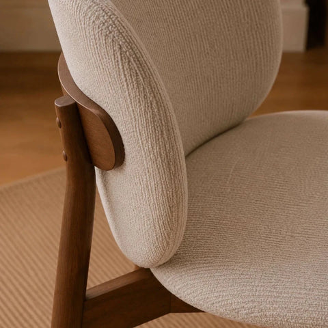 Fabric Close up of Portofino cream chenille dining chair Featuring padded curved backs, walnut-effect wooden frames and elegant contemporary styling.
