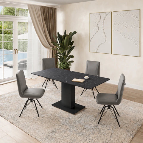 A modern dining set featuring a rectangular black marble-top table with a black pedestal base, surrounded by four gray upholstered swivel chairs with black metal legs, set on a light beige shag rug in a bright dining room.