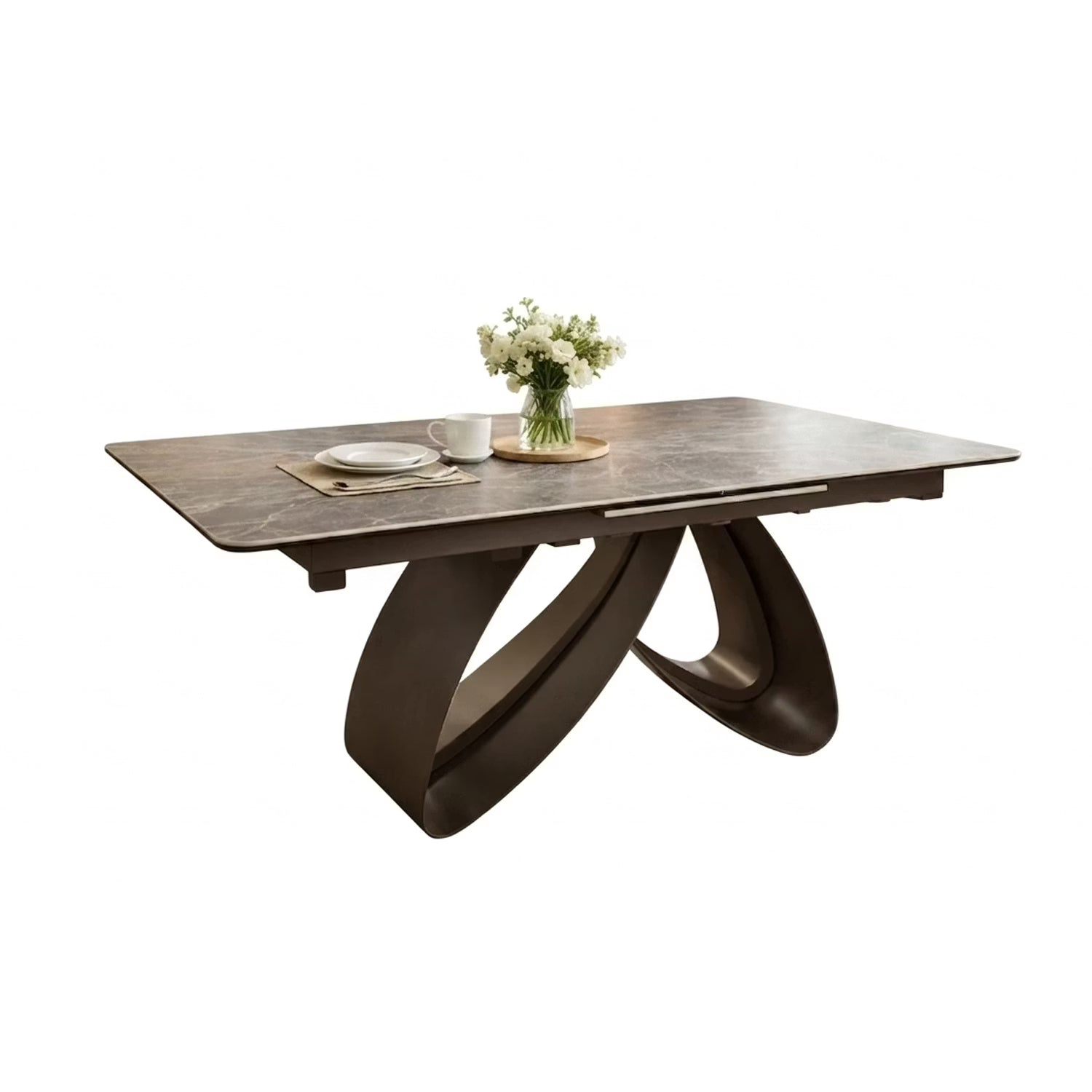 A modern rectangular dining table with a Armani grey  Ceramic top and a sculptural curved base, styled with a vase of white flowers and a cup on a light gray background.