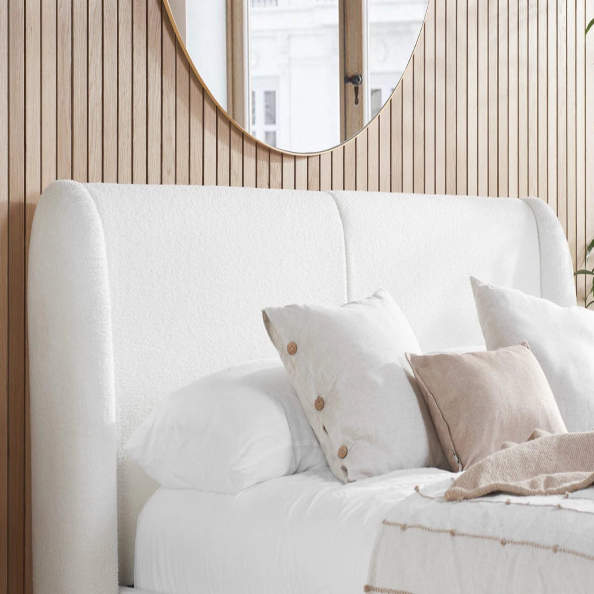 Curved bouclé headboard with soft padded cocoon design.